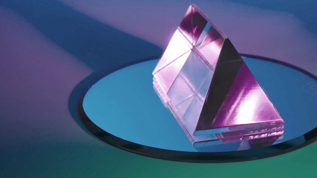 Fotografie eines Kristalls auf einer spiegelnden Fläche.